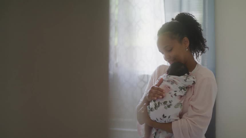 The woman is cradling her baby