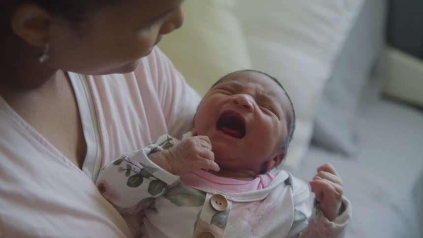 Mother with a newborn baby in her arms crying
