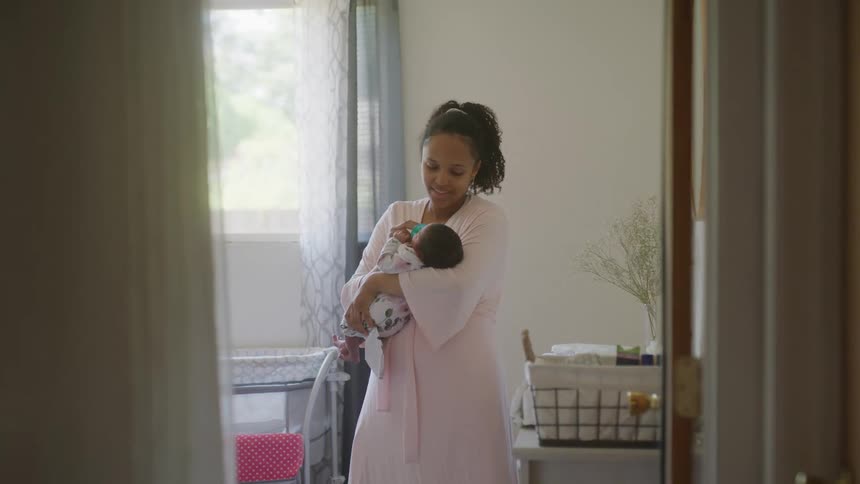 A mother is holding her newborn at home