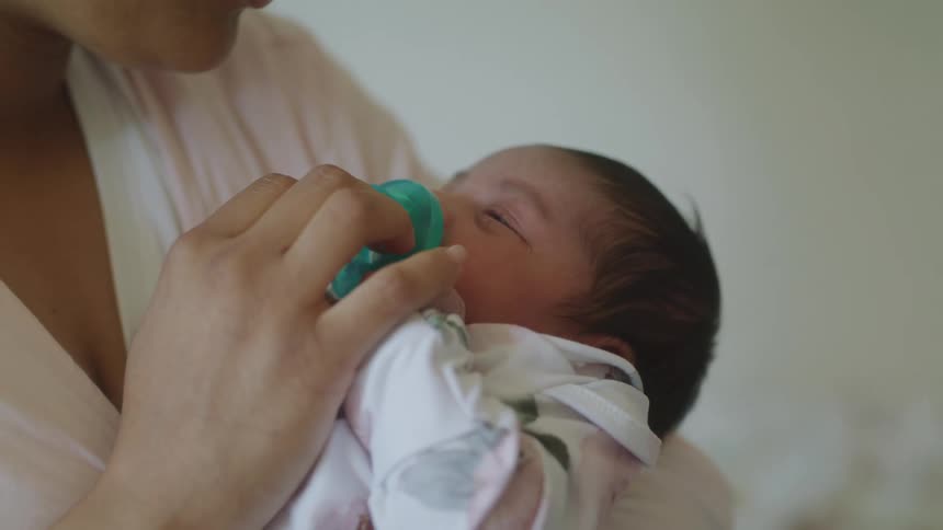 Newborn baby on the lap of an adult