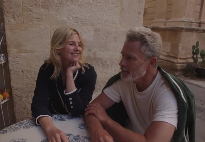 A young woman and an older man talking at a table
