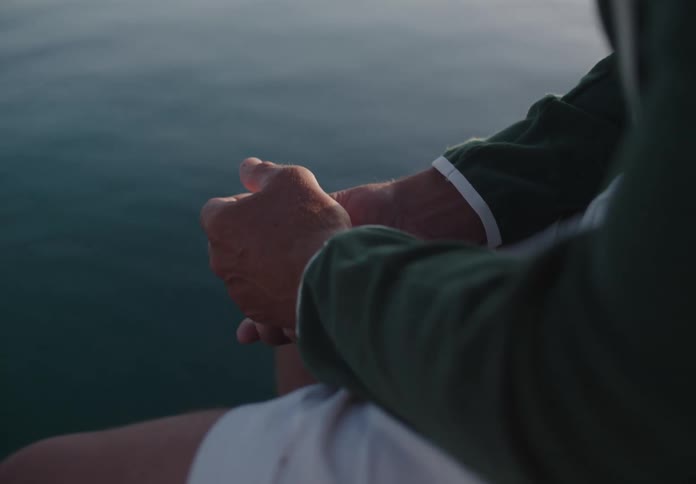 A person sits by the waters edge