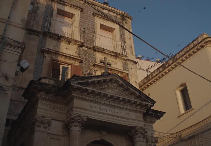 An old europeanstyle building with religious architecture is shown under warm daylight
