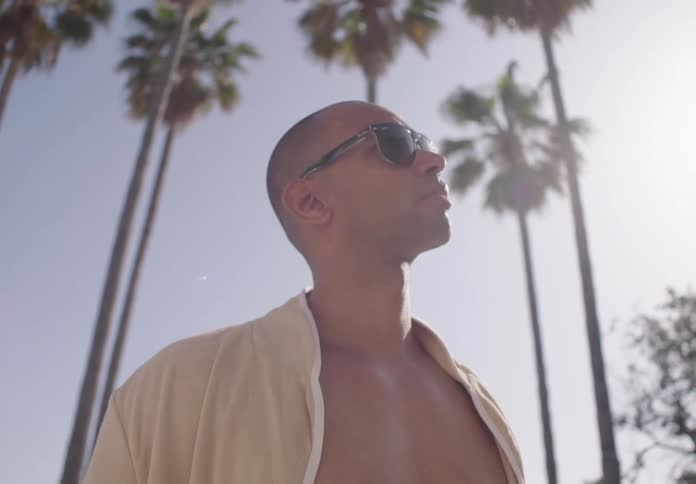 A man looks up at the sunny sky