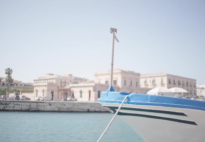 The boat is docked by the city