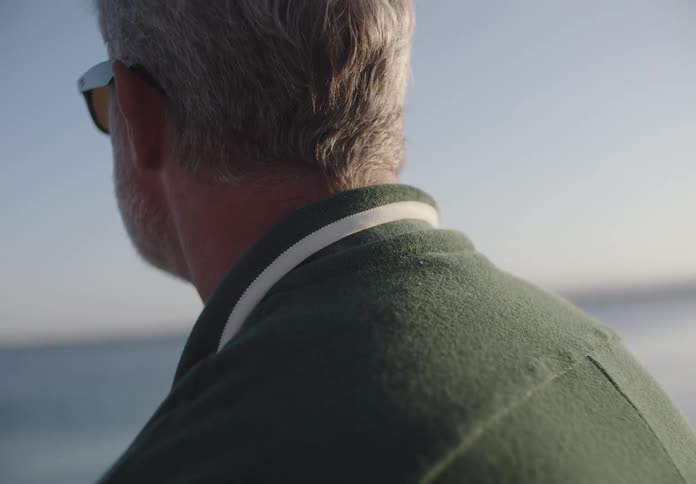 A man stares out across the water