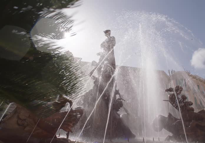 A bird flies over the fountain