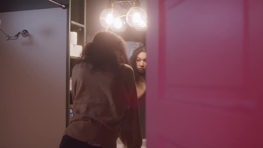 Woman looking at herself in the mirror