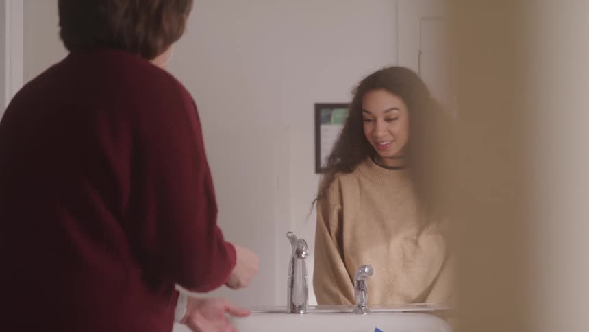 A woman washes her hands in the sink