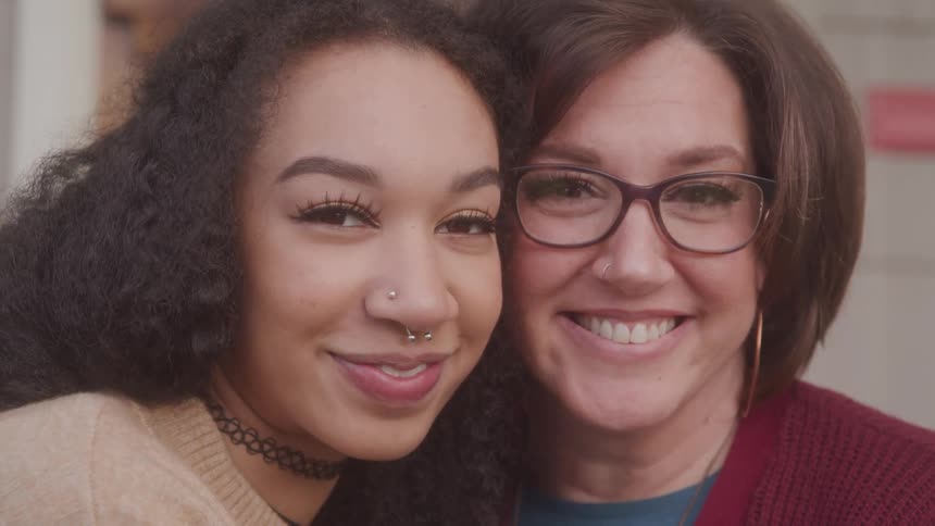 Two women smile closely together for a portrait shot