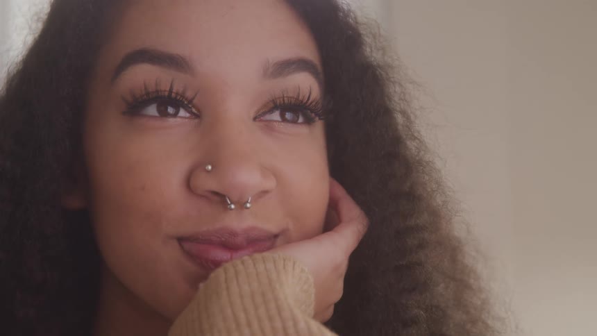 Curly haired woman with happy and thoughtful expression