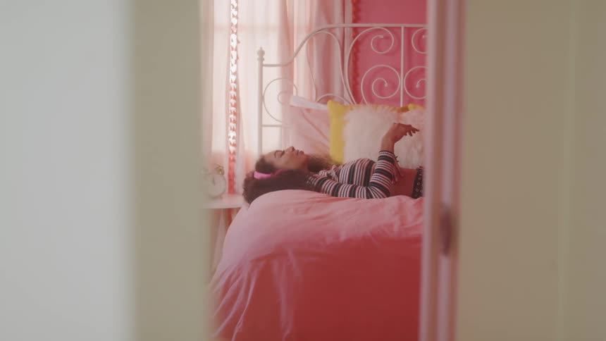 A girl lies in bed listening to music