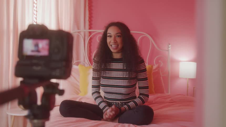 The woman smiles and talks to her camera