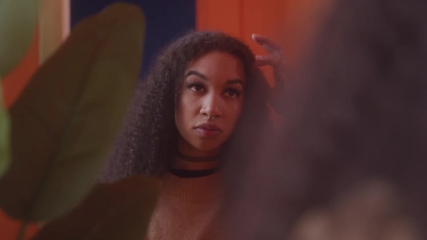 A woman adjusts her hair in the mirror