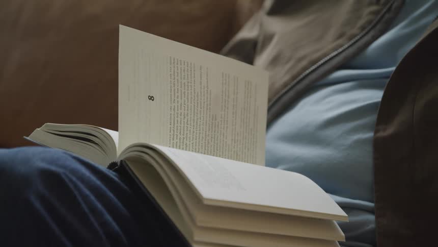 Persons hand turning the page of a book