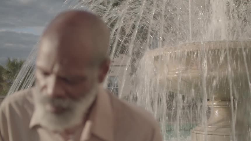 A man is positioned in front of a fountain
