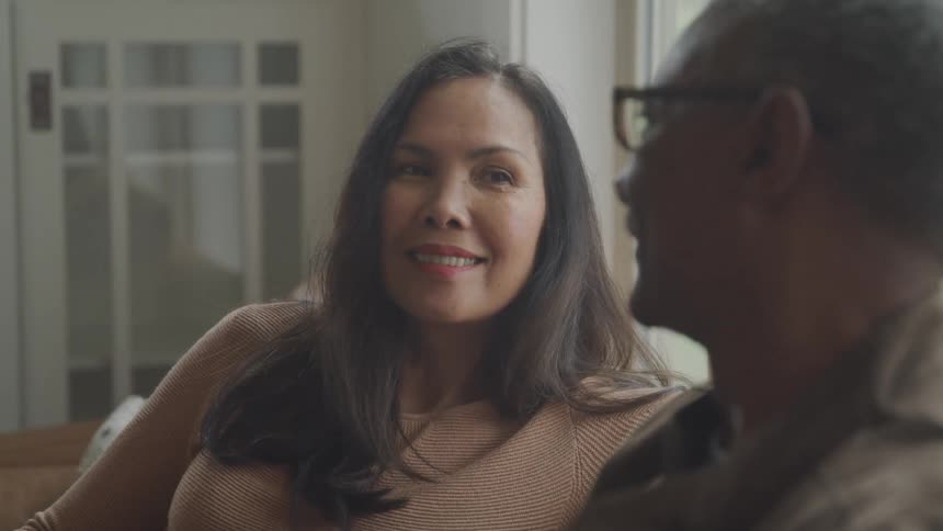 Couple sitting on a sofa and looking at each other happily