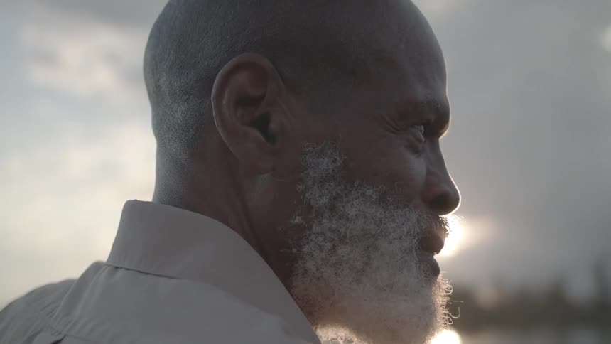 Side portrait of a white bearded man outdoors