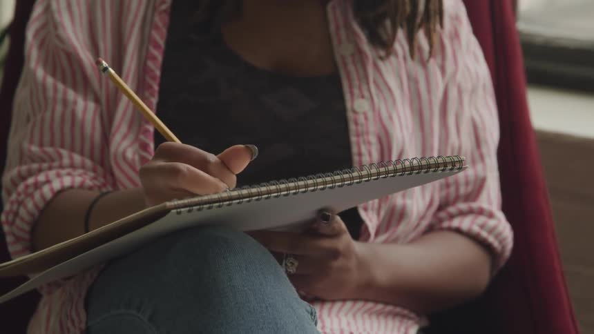 A girl sketches in a sketchpad