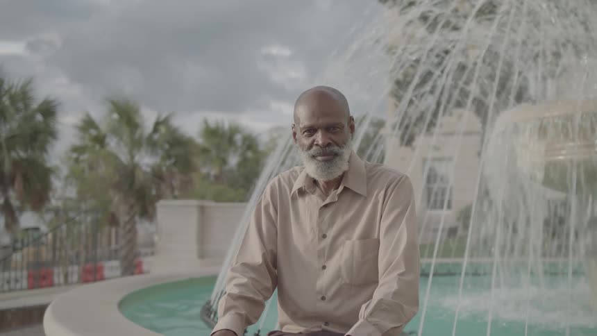 A man sits on the edge of a fountain