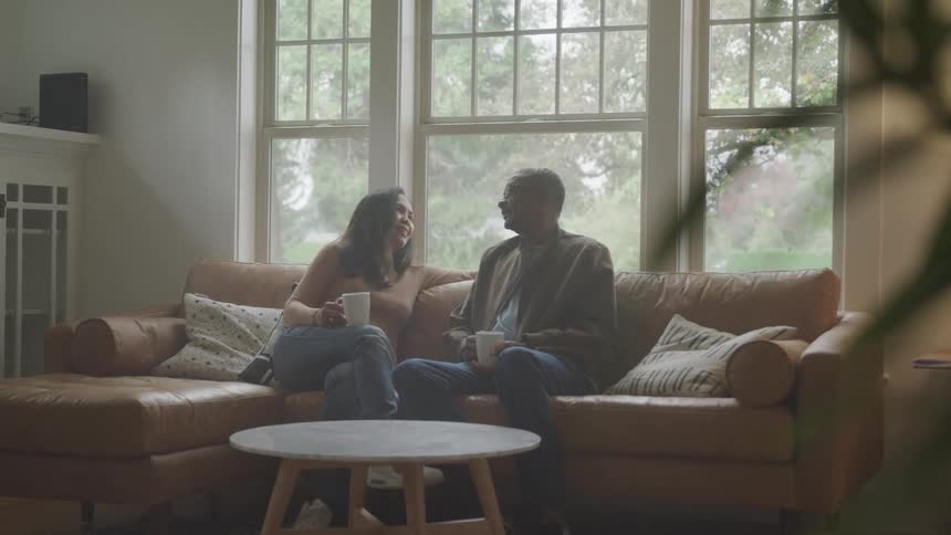 Man and woman sitting with a mug in their hands talking