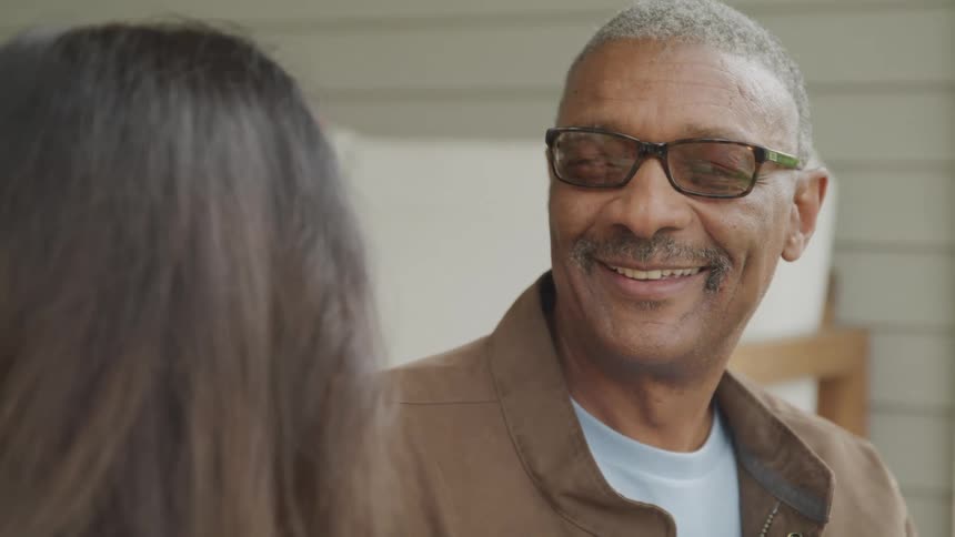 The man is smiling at a woman outside