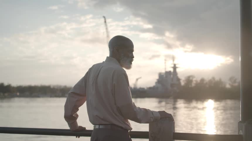 A man is leaning on the railing by the waterway