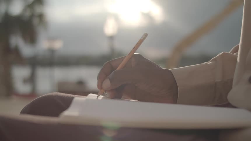 Person with a pencil writing in a notebook