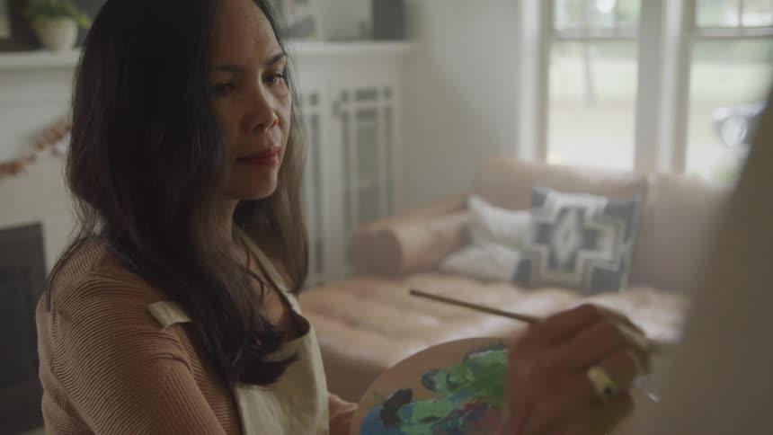 A woman is painting on the canvas