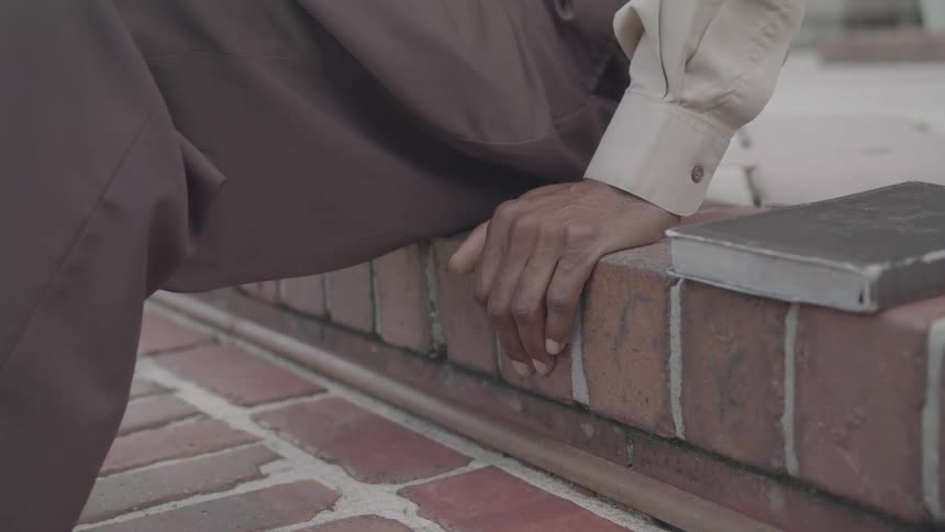 A man sitting on the steps picks up his book