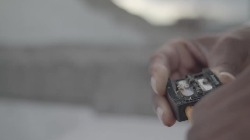 Hand sharpening a pencil in a sharpener