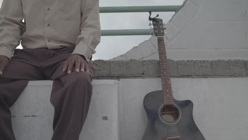 Person sitting next to a guitar