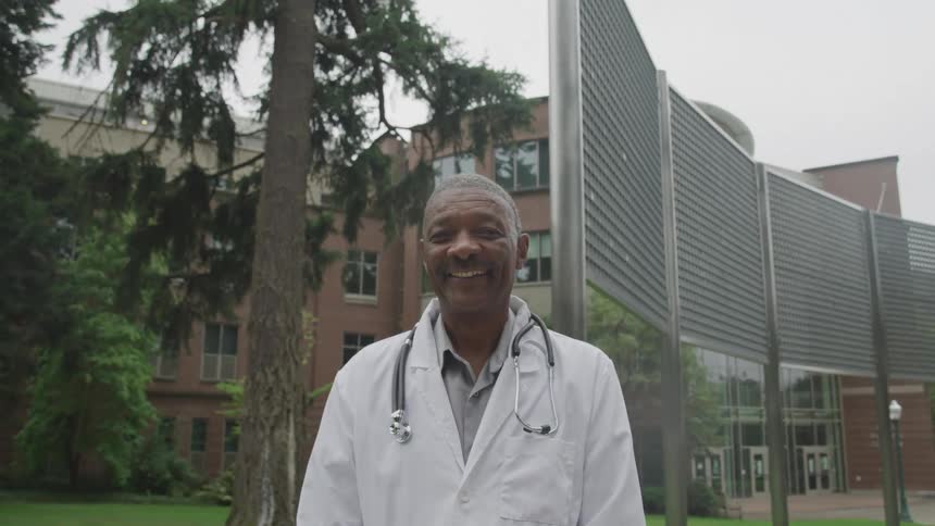 Man with a smile and wearing a medical coat