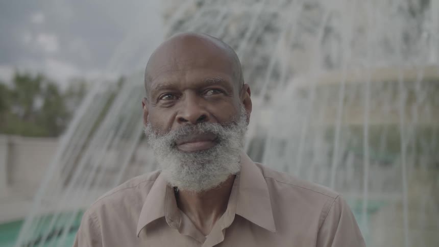 A man is smiling by the fountain