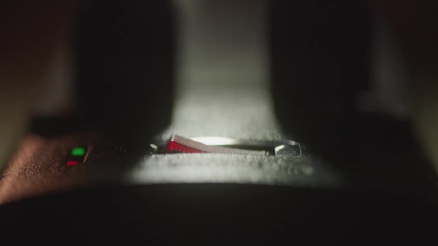 Close up of a light switch toggled on by a person in a room at night