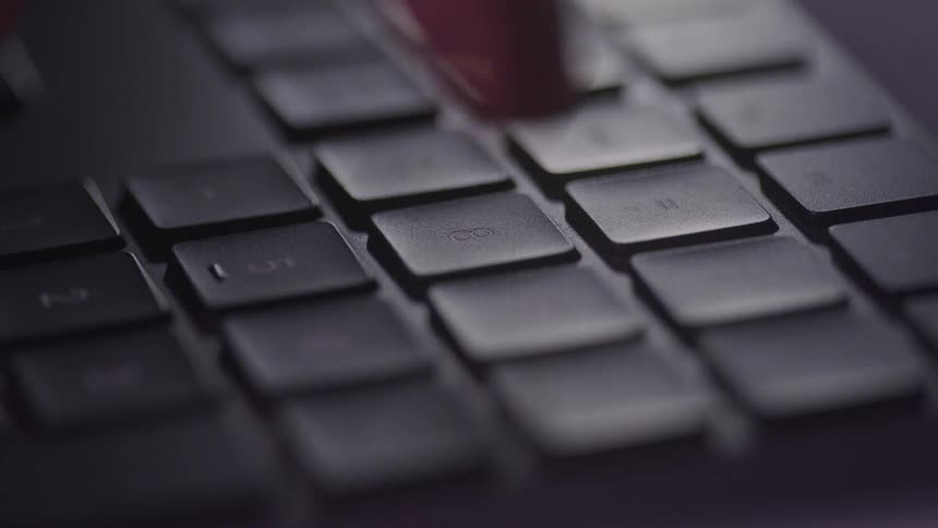 A finger taps at a keyboard