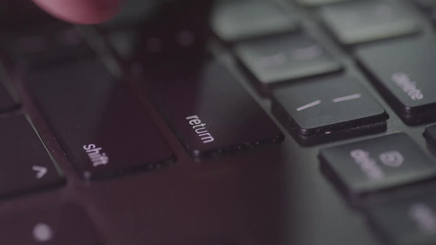 A person types on a laptop computer