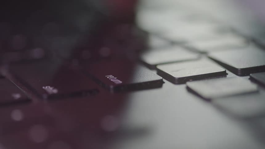 Close up of keys on a computer keyboard as a person types