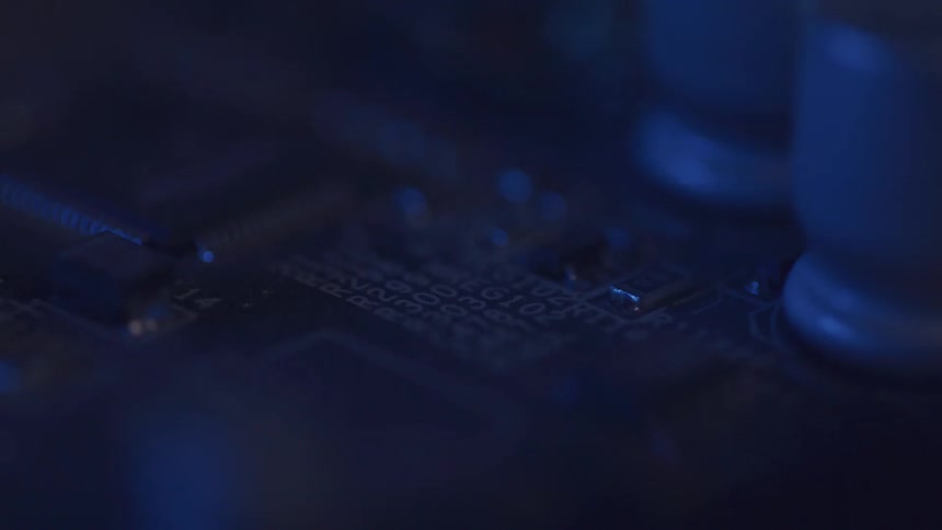 Close up of electronic motherboard components under blue lighting