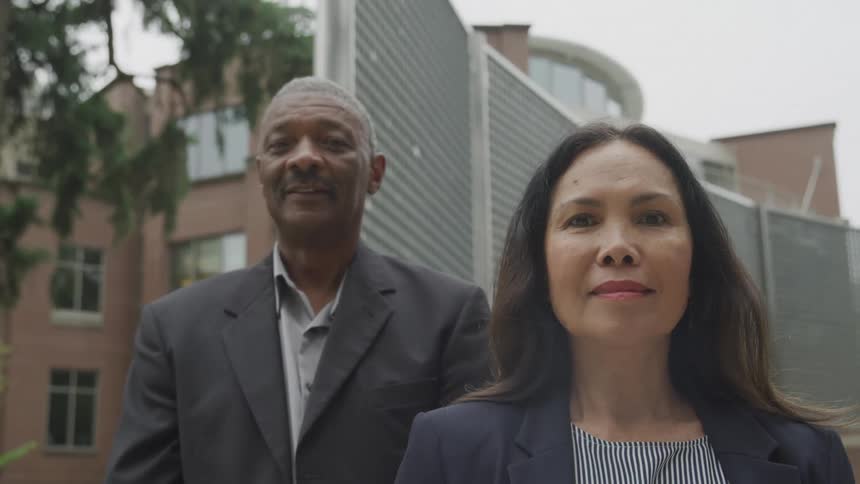 Face of a man and a woman standing at the gate of a house at daytime