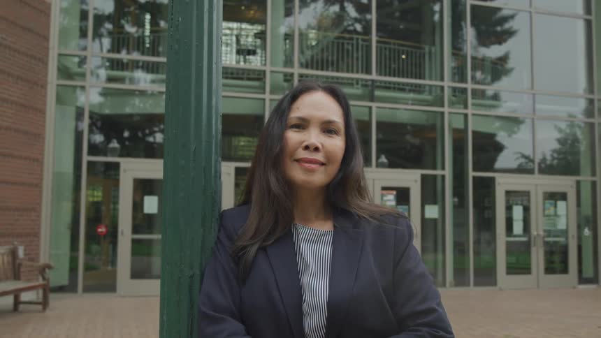 Woman with happy expression in an outdoor setting wearing a blazer
