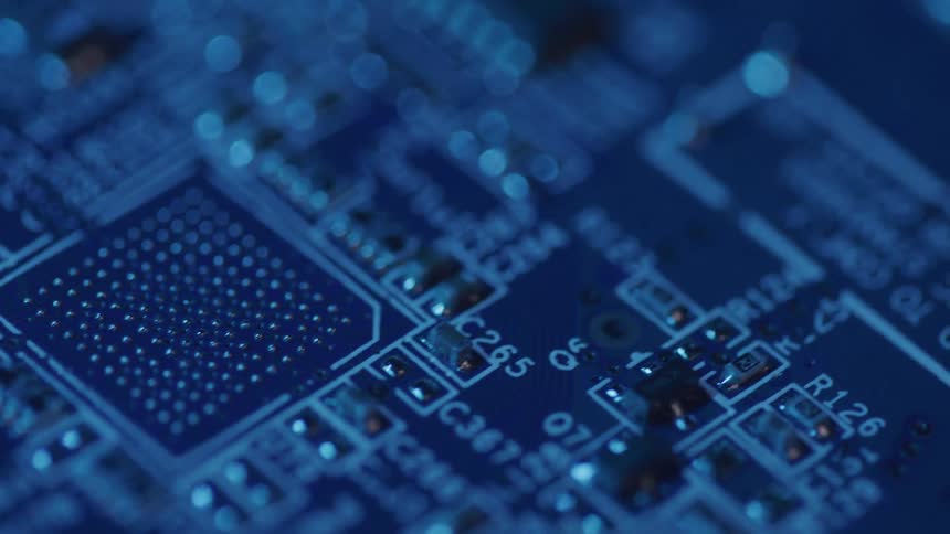 Close up of an electronic motherboard in a room with blue lighting
