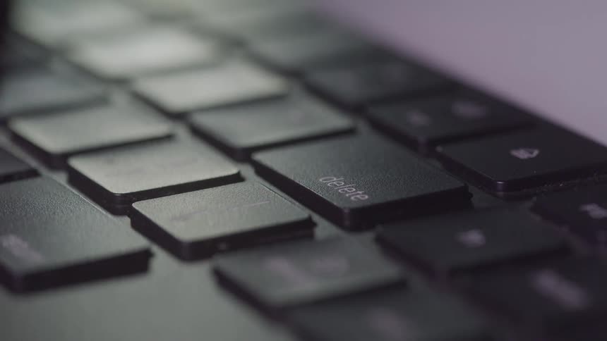 Fingers typing on a black keyboard