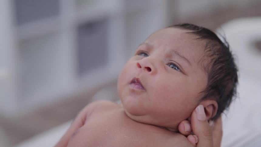 Newborn baby in a persons hand