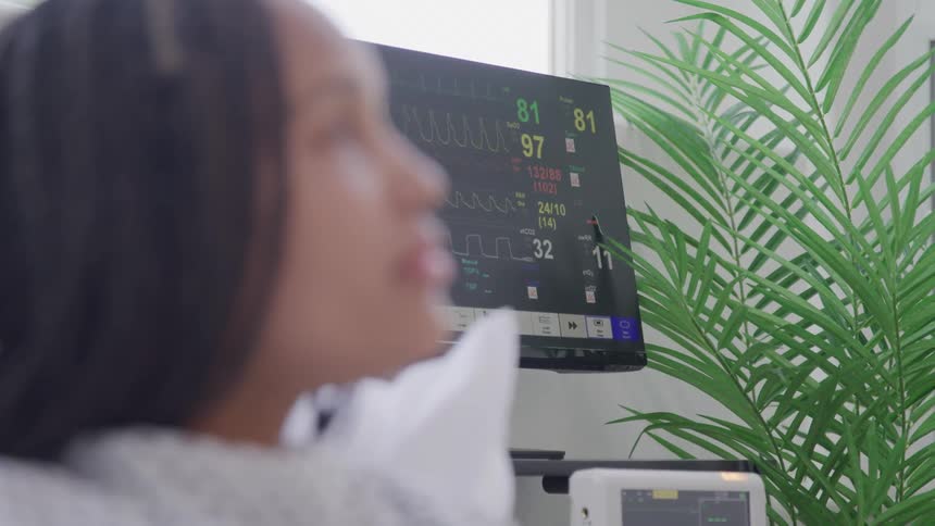 Hospital ekg monitor screen monitoring female patients heart rate