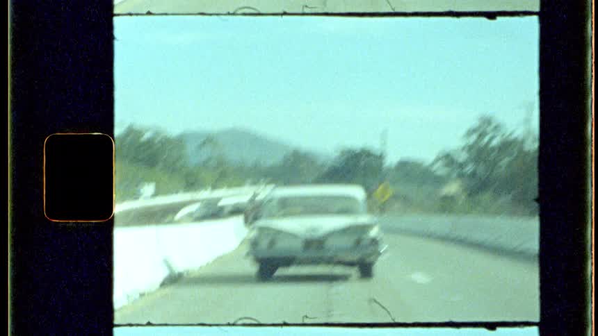 Classic car driving on a highway during the day