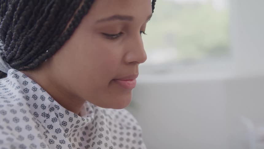 A female patient sits in the hospital around midday