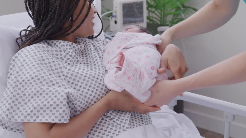 The nurses hands a new mom her baby