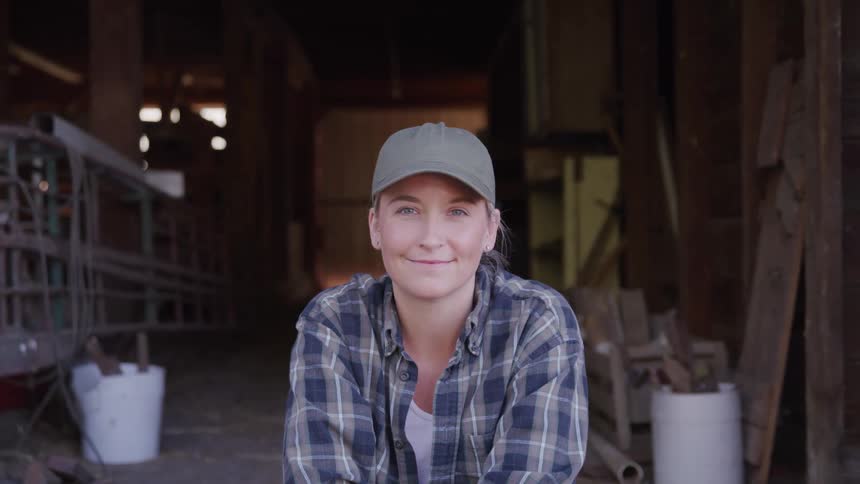 Woman in a cap sitting on a ranch