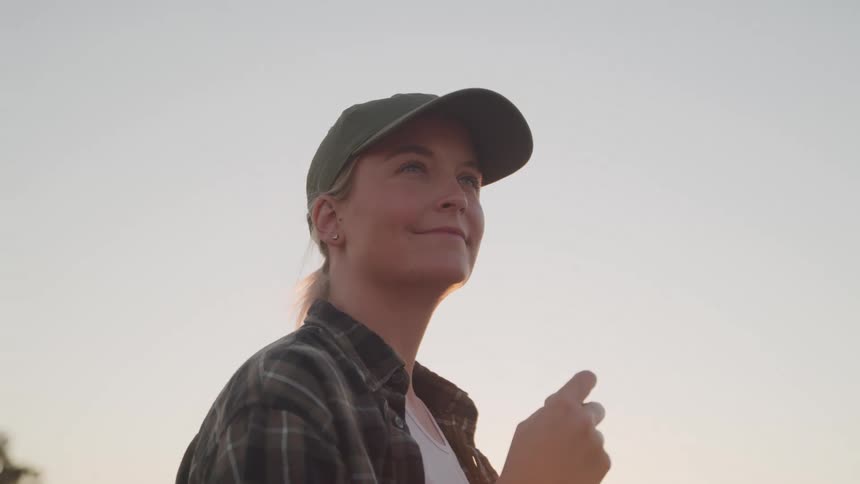 Close up portrait of a young woman smiling while standing outdoors at sunset